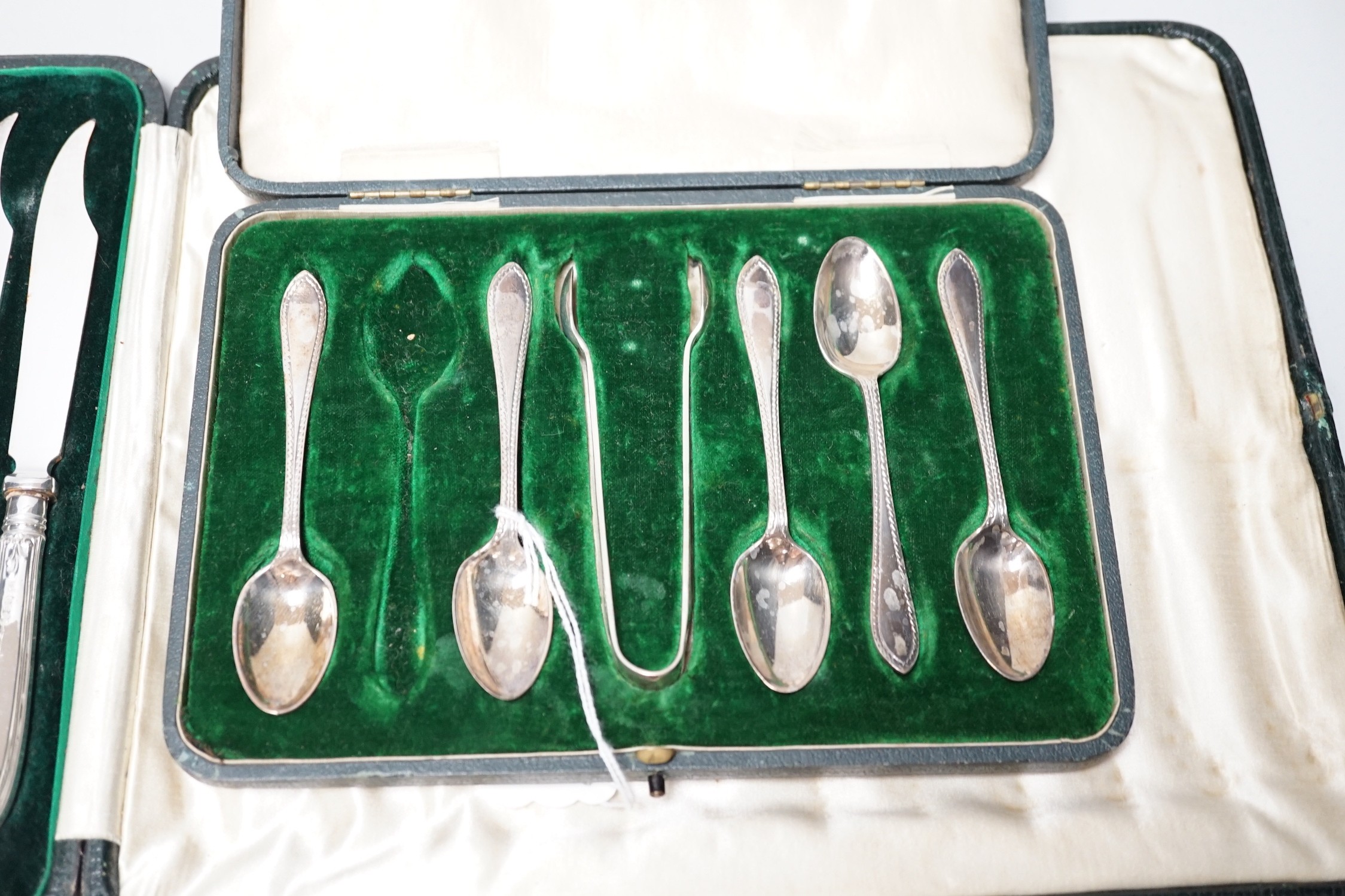 A cased set of twelve silver handled dessert knives, six seal-top teaspoons, five (ex 6) teaspoons and tongs.